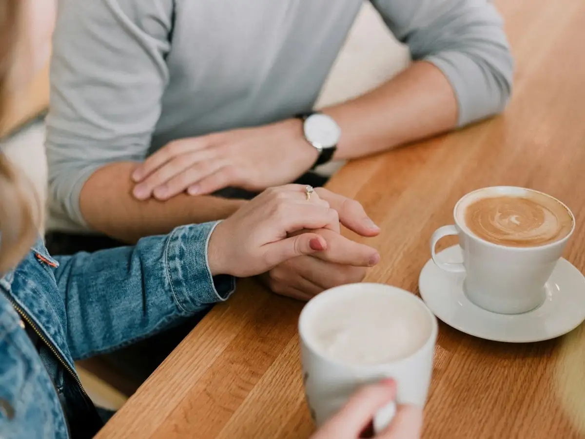 Man and woman holding hands, offering support