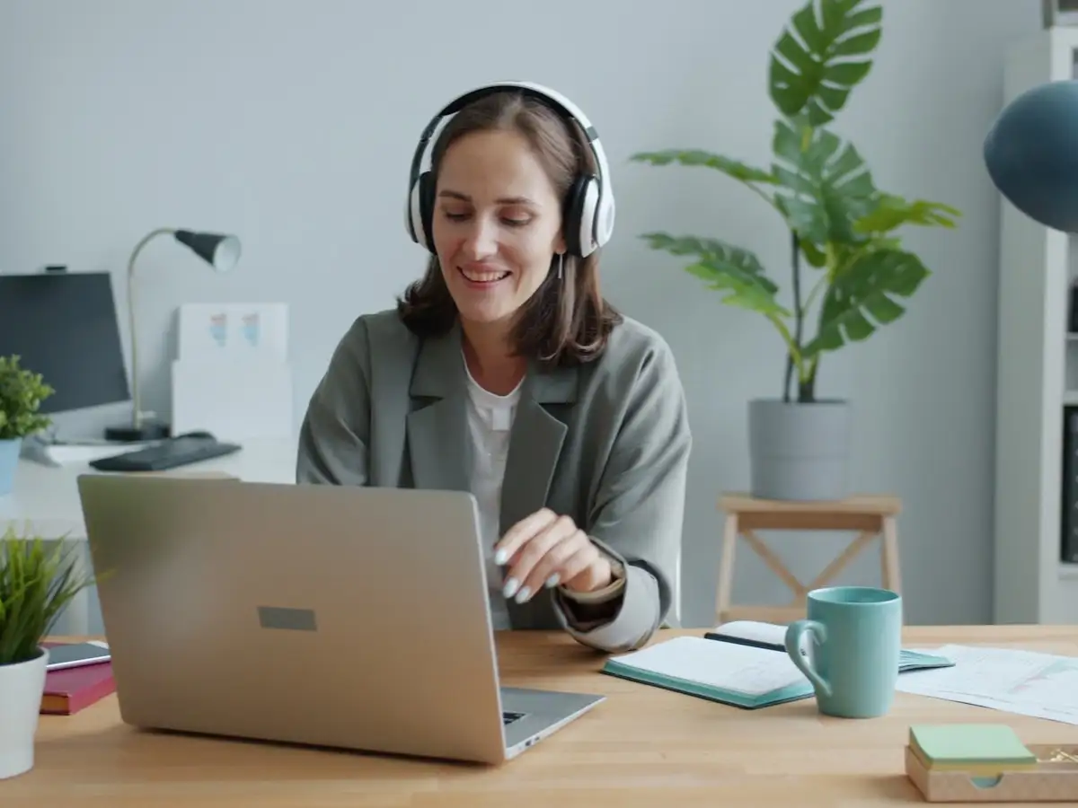 Person using headphones while working on a laptop