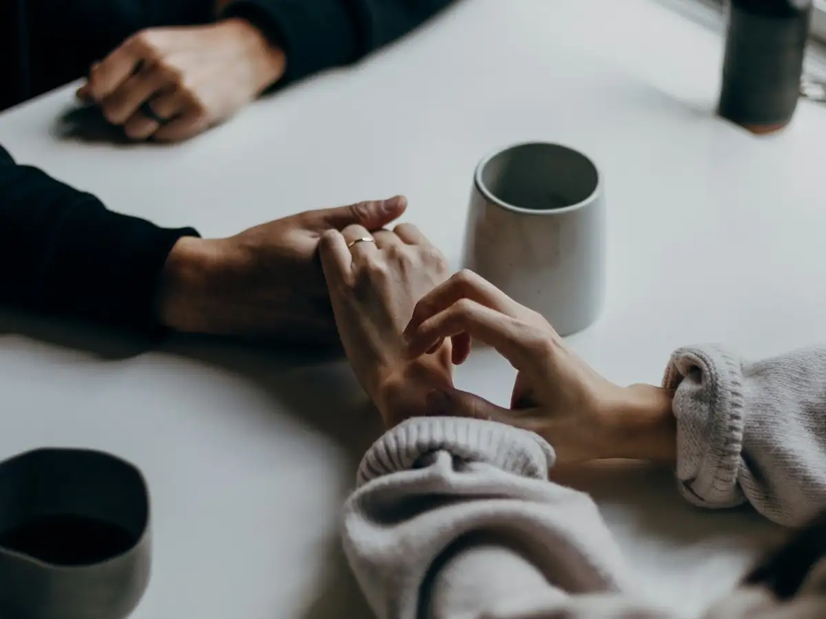 Two people holding hands across a table