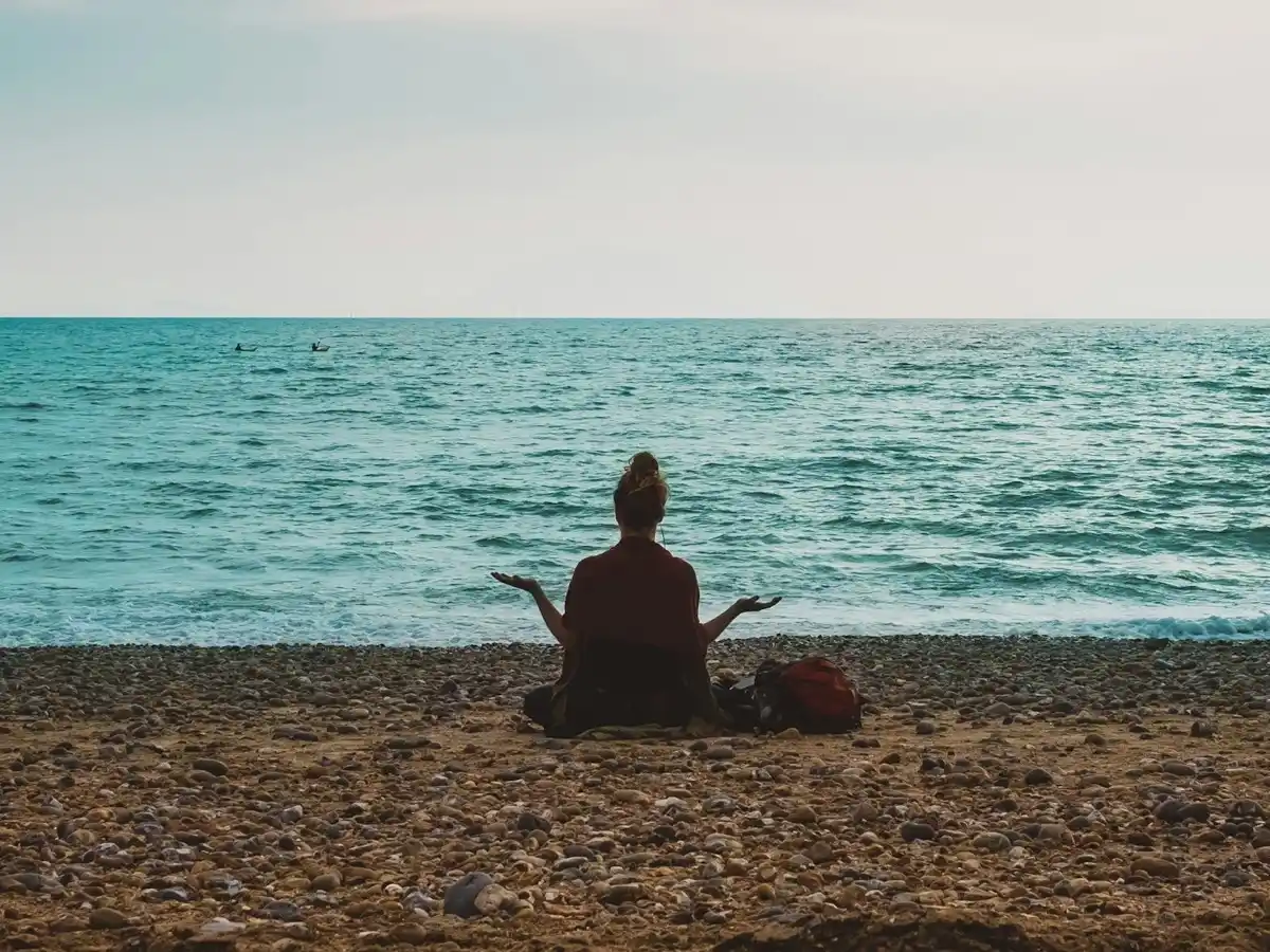 Person doing yoga calmly by the seashore