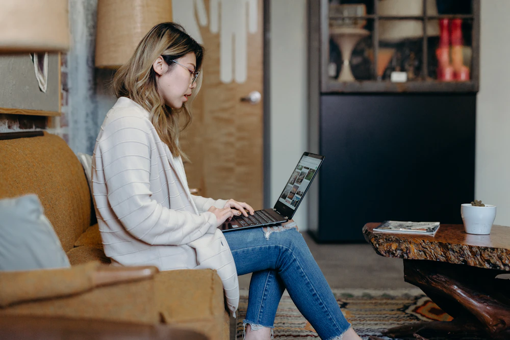 Woman typing on a laptop while venting anonymously online about a breakup