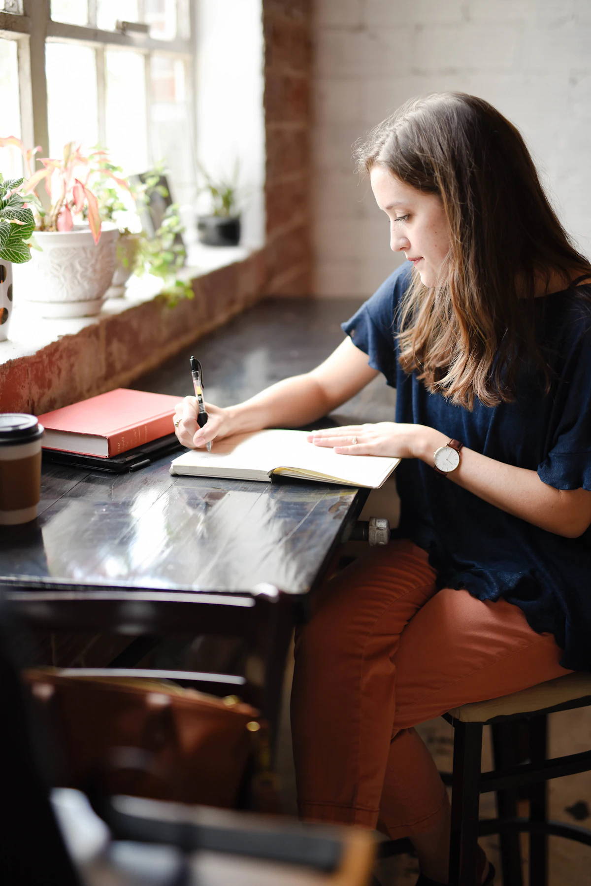 Woman journaling at a table, working through a decision on her own