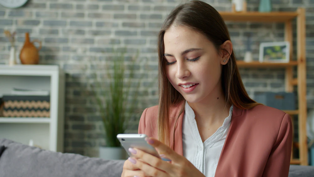 Woman scrolling through her phone on the couch