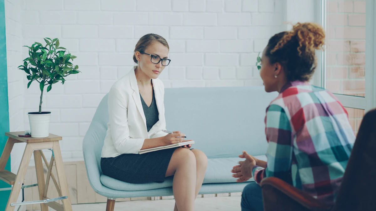 A licensed therapist listening attentively while a client speaks during a clinical session