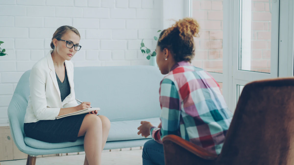 A licensed counselor taking notes while a client speaks during a supportive session