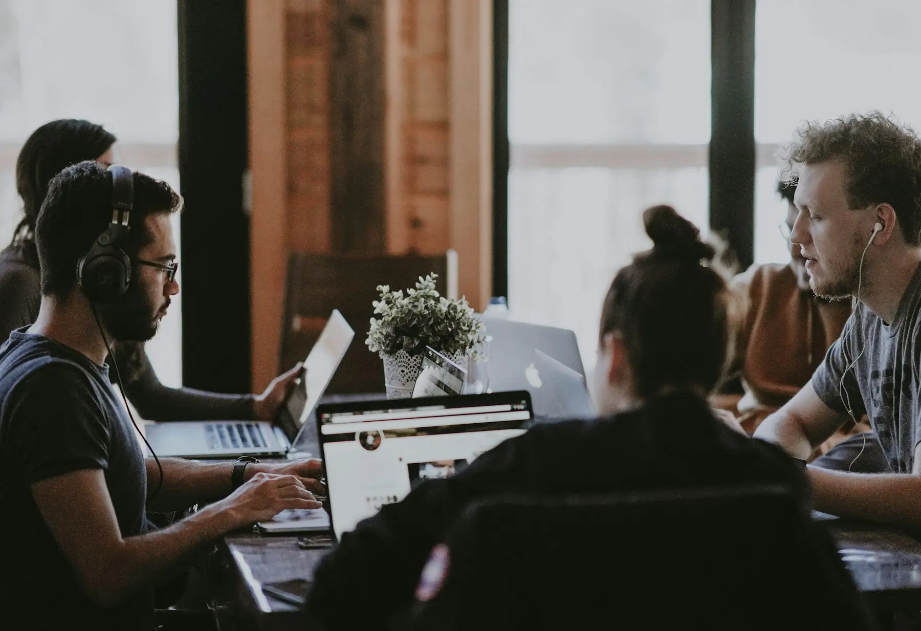 Young adults working on laptops together in a shared workspace