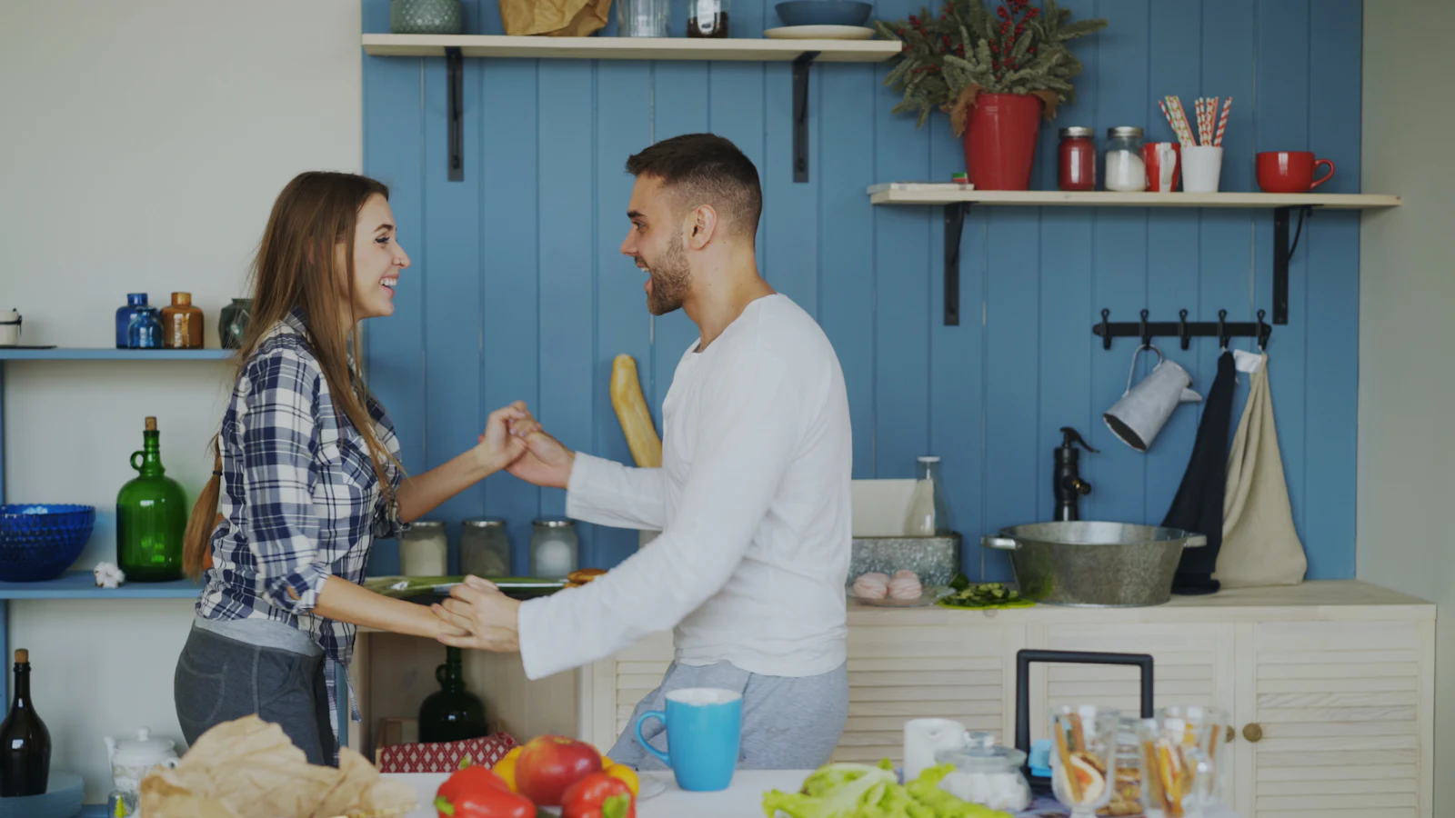 A couple laughing together in a bright kitchen